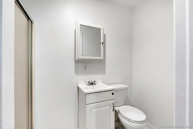 a bathroom with a toilet sink vanity and mirror