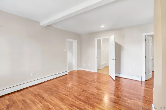 a view of an empty room with wooden floor