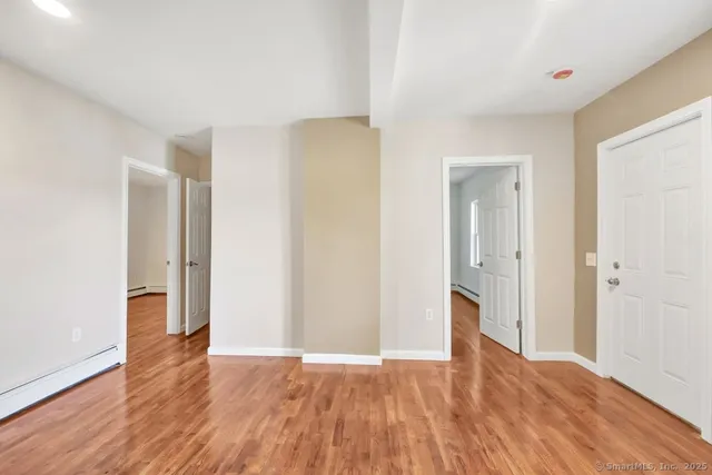 a view of empty room with wooden floor