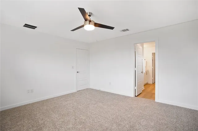en empty room with ceiling fan and window