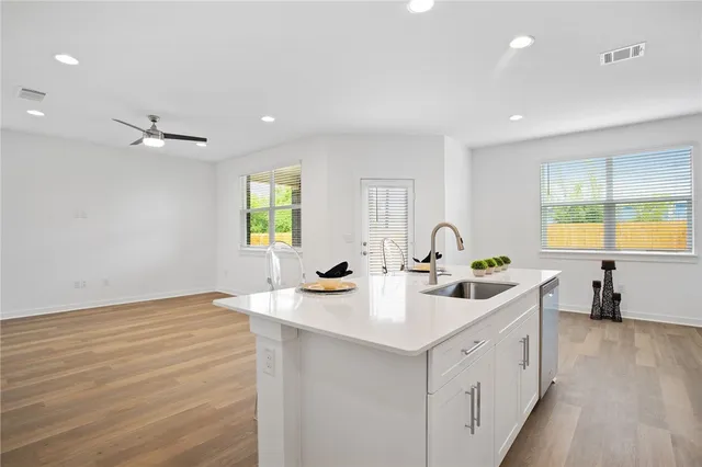 a kitchen with a sink window and cabinets