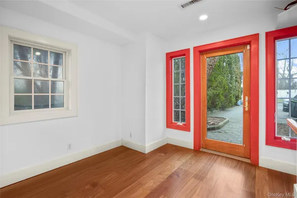 a view of a big room with wooden floor and windows