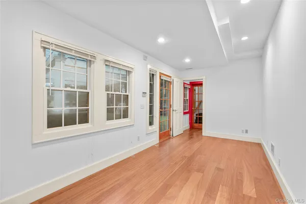 an empty room with wooden floor and windows