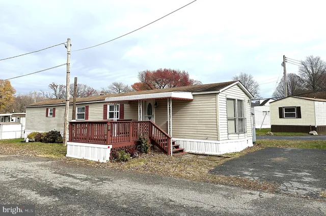 a view of a house with a large space and a road