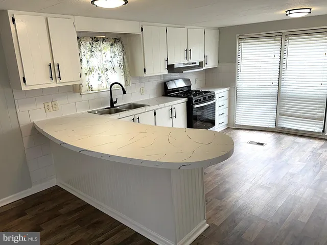 a kitchen with stainless steel appliances a sink window and cabinets
