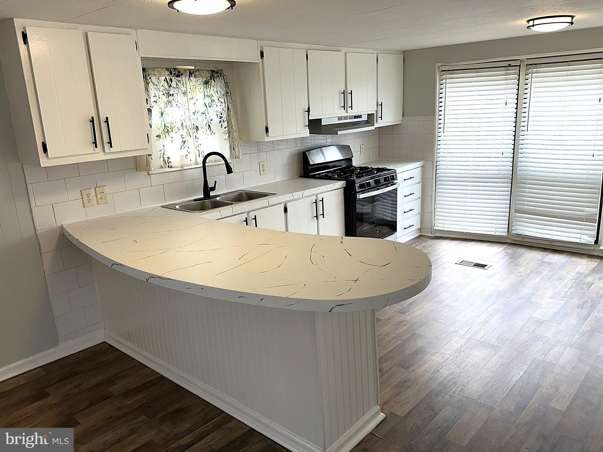 2400 Lincoln Avenue, Unit 15 Sparrows Point, MD 21219 - Photo 2 of 24 a kitchen with stainless steel appliances a sink window and cabinets