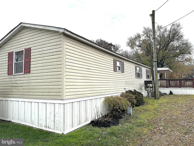 a view of a wooden house with a small yard and wooden fence