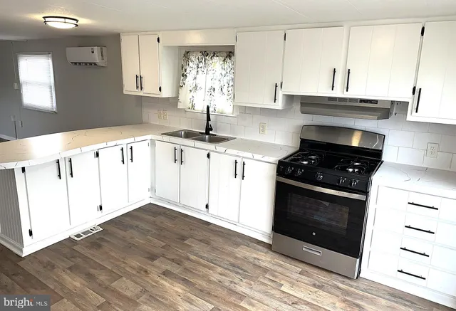 a kitchen with granite countertop a stove a sink and a microwave