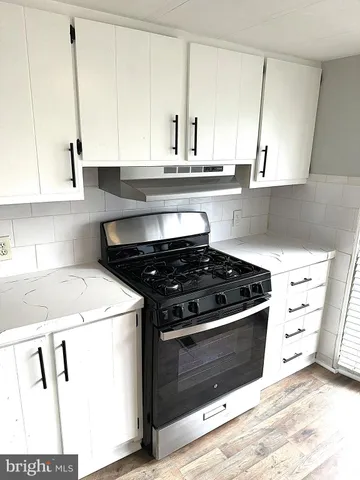 a kitchen with granite countertop a stove and a sink