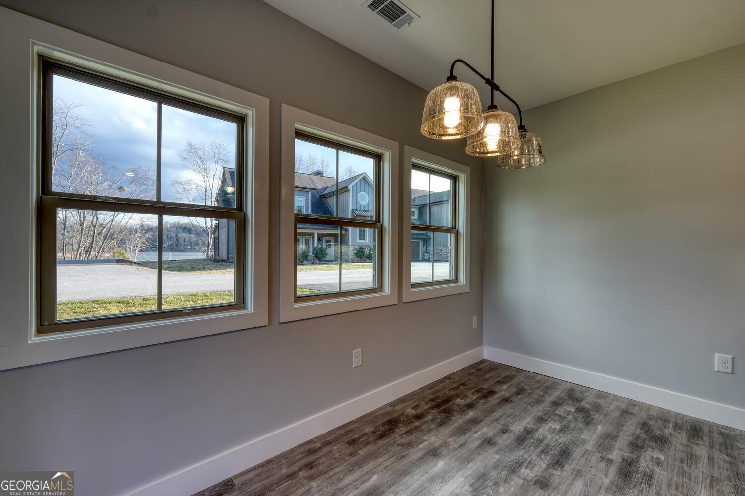 98 Brett Way, Unit F Hiawassee, GA 30546 - Photo 17 of 40 a view of wooden floor a chandelier and windows in a room