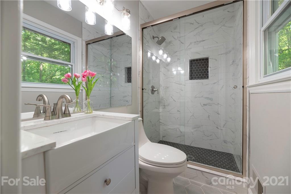 7316 Watercrest Road Charlotte, NC 28210 - Photo 16 of 28 a bathroom with a shower sink vanity mirror and toilet