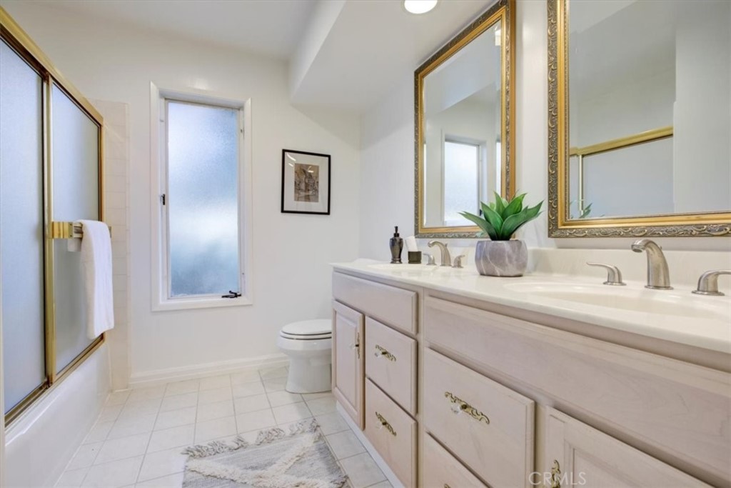 1980 El Arbolita Drive Glendale, CA 91208 - Photo 17 of 43 a bathroom with a toilet a sink a tub and mirror