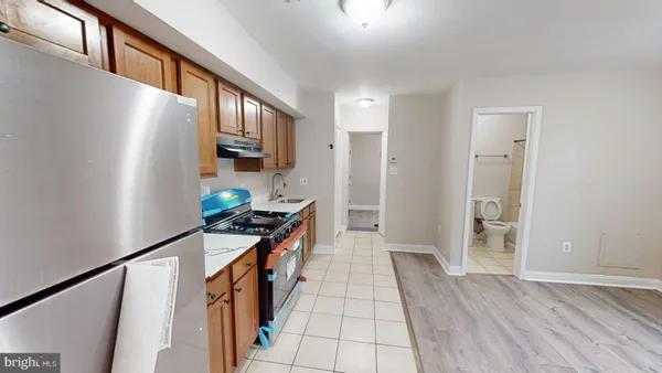 a hallway with stainless steel appliances granite countertop a refrigerator and a stove
