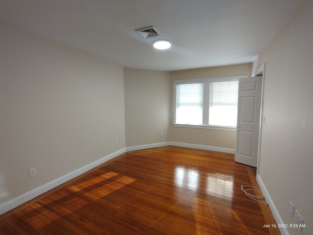 62 Washington Street, Unit 62 Wellesley, MA 02481 - Photo 9 of 18 a view of empty room with wooden floor and fan