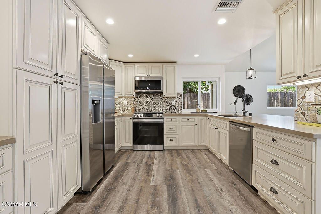1772 Fred Avenue Simi Valley, CA 93065 - Photo 11 of 43 a kitchen with white cabinets and stainless steel appliances
