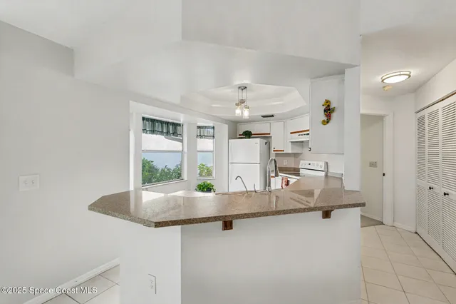 a dining hall with stainless steel appliances granite countertop a granite counter tops and a view of living room