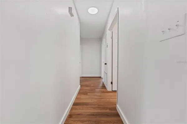a view of a hallway with wooden floor and staircase