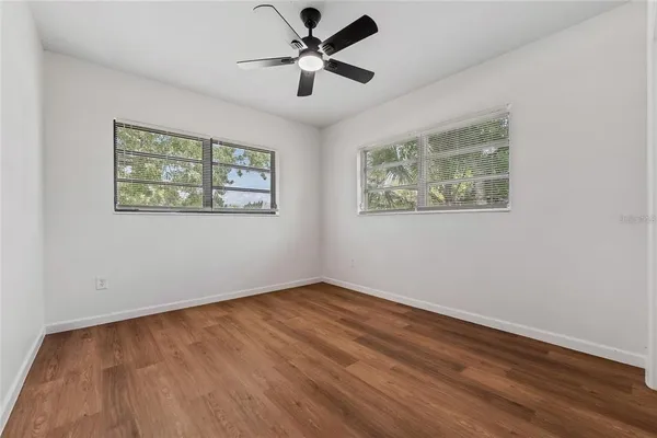 a view of an empty room with wooden floor