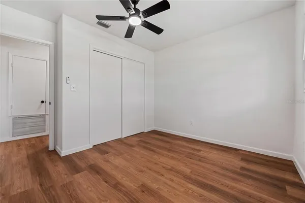 a view of an empty room with wooden floor