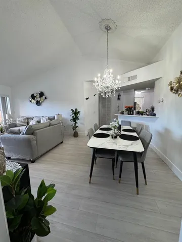 a living room with furniture a chandelier and a table