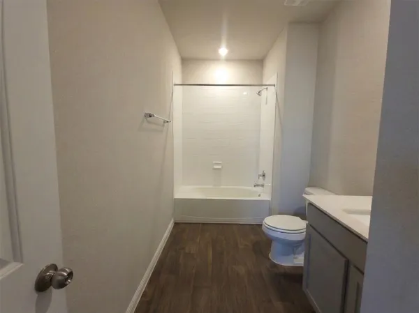 a bathroom with a granite countertop sink a toilet and shower