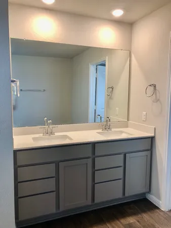 a bathroom with a double vanity sink and a mirror
