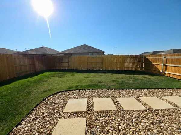 a view of a yard with wooden fence