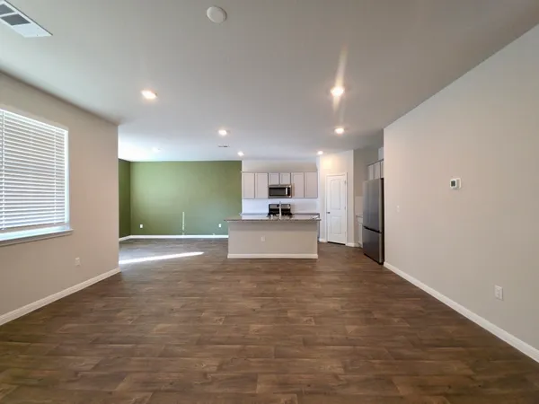a view of kitchen with kitchen island stainless steel appliances refrigerator sink and cabinets