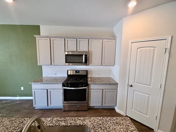 a kitchen with a sink appliances and cabinets