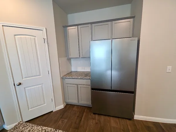 an empty room with wooden floor and cabinet