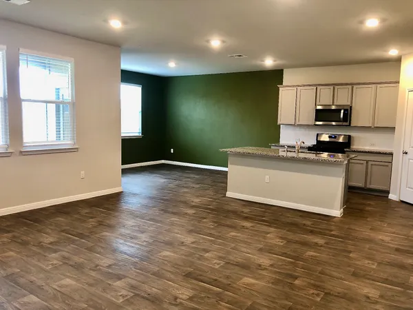 a kitchen with stainless steel appliances granite countertop a stove a sink and a microwave