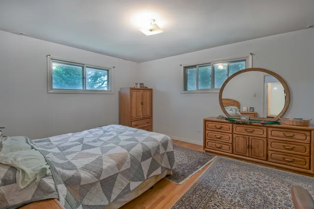 a bedroom with a bed a mirror on dresser and a chandelier