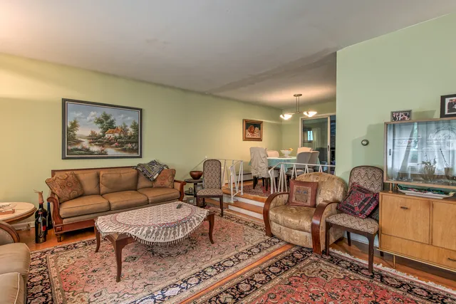 a living room with furniture a rug and a table