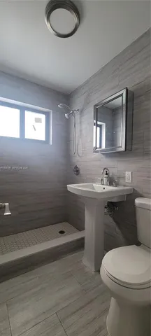 a bathroom with a sink a toilet and mirror