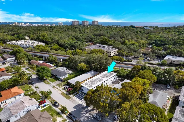 an aerial view of residential houses with outdoor space and trees