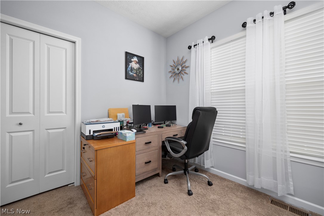 109 West Spring Drive Elyria, OH 44035 - Photo 25 of 46 Bright room featuring two windows with horizontal blinds, light gray walls, plush carpet flooring, and a bifold closet door