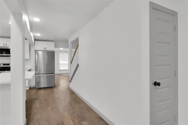 a kitchen with a refrigerator and wooden floor