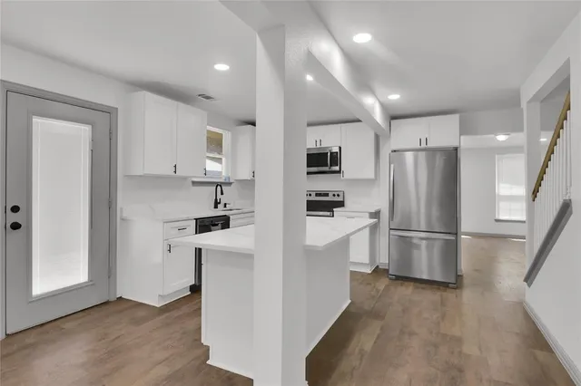 a kitchen with white cabinets and stainless steel appliances