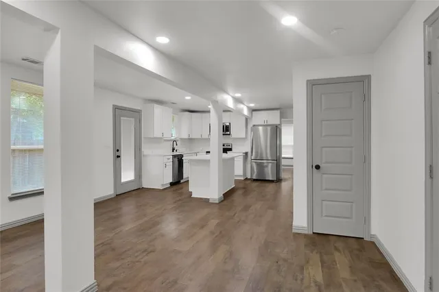 a view of a kitchen with wooden floor and windows