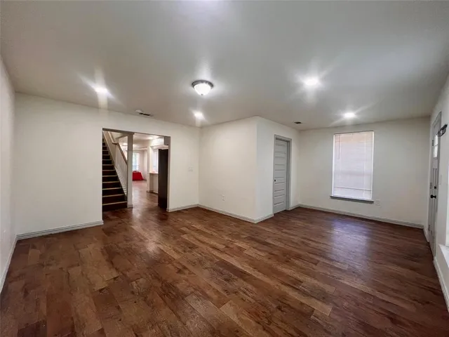 an empty room with wooden floor and closet