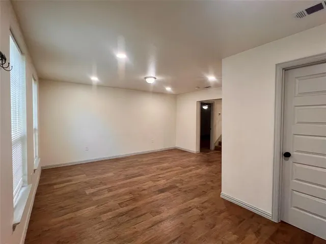 an empty room with wooden floor and closet