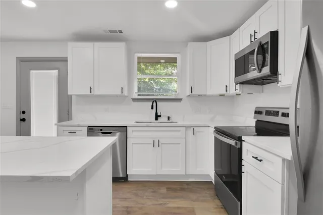 a kitchen with stainless steel appliances a stove microwave sink and cabinets