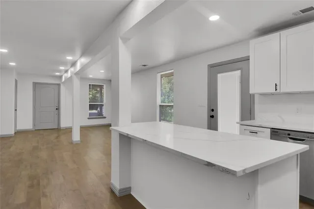 a kitchen with a sink a refrigerator and white cabinets