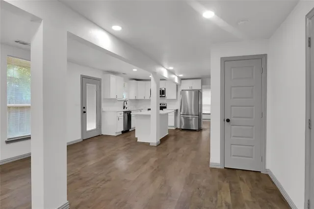 a view of a kitchen with a refrigerator and a sink
