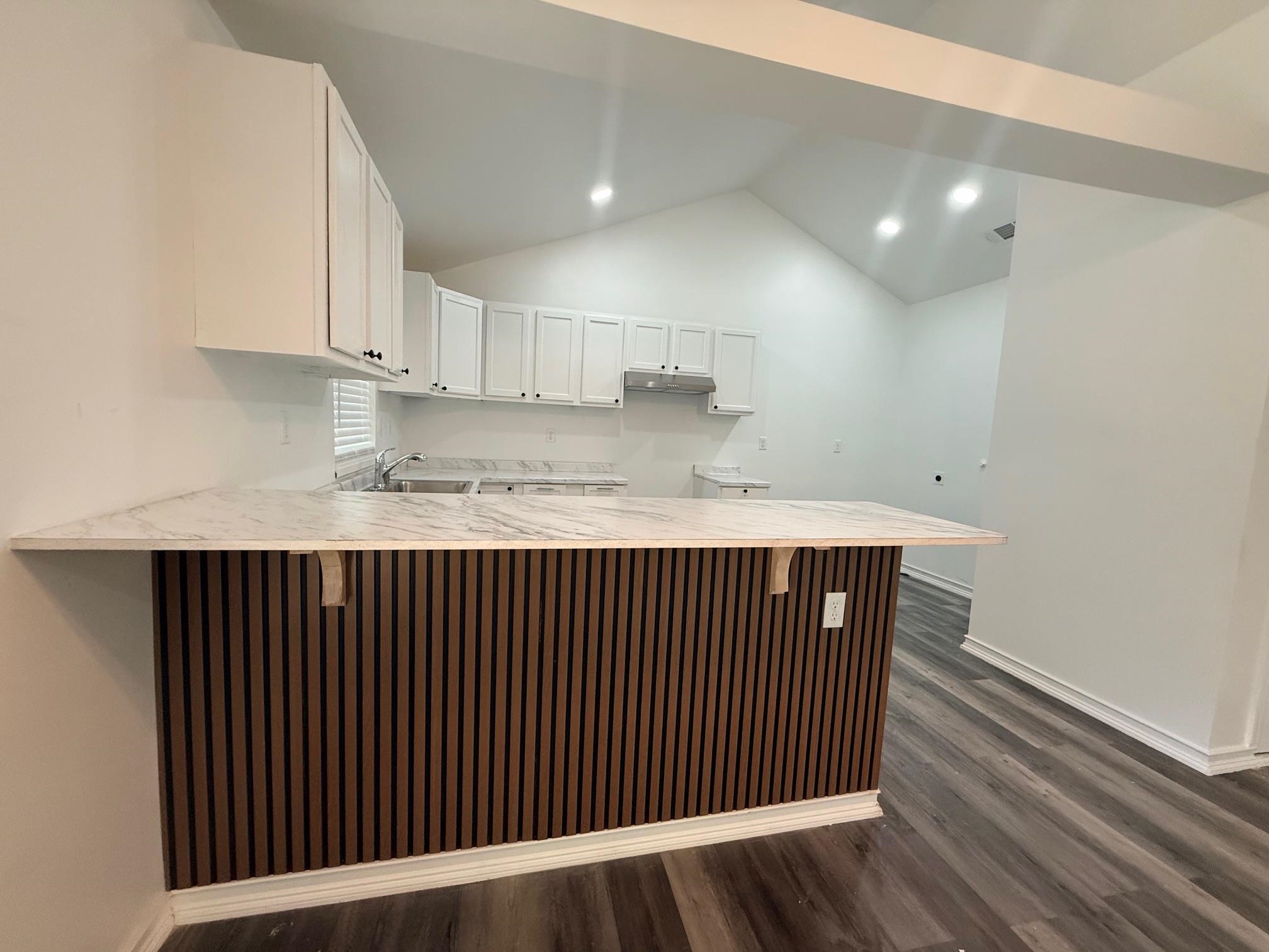3054 Lotus Road Memphis, TN 38109 - Photo 11 of 29 a kitchen with kitchen island wooden floors wooden cabinets a sink and a counter top space