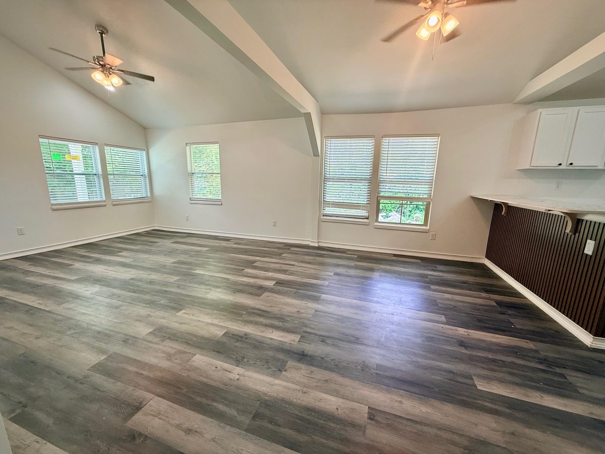 3054 Lotus Road Memphis, TN 38109 - Photo 6 of 29 an empty room with wooden floor chandelier fan and windows