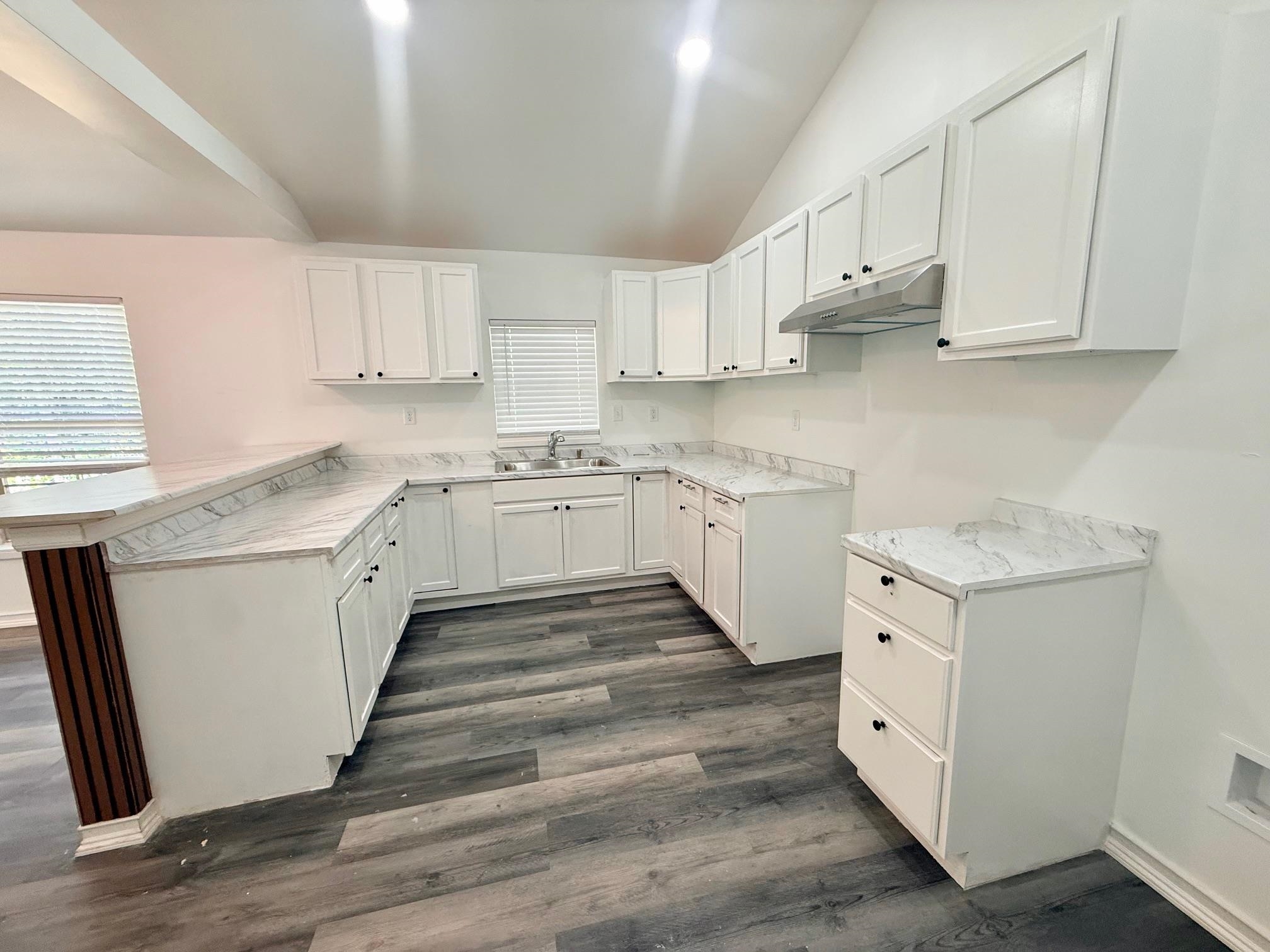 3054 Lotus Road Memphis, TN 38109 - Photo 9 of 29 a kitchen with granite countertop white cabinets and white appliances