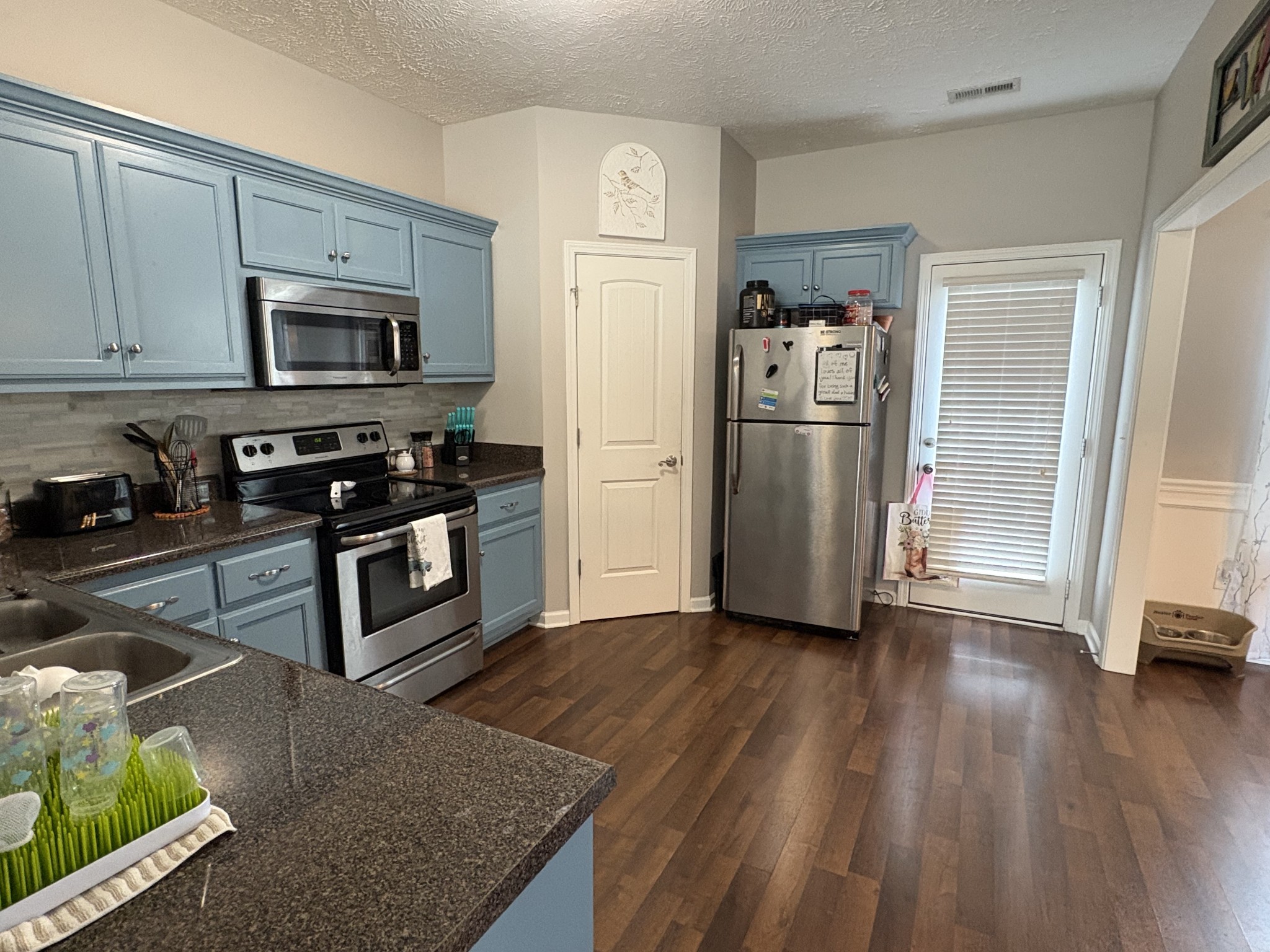 2455 New Holland Circle Murfreesboro, TN 37128 - Photo 6 of 12 a kitchen with granite countertop a refrigerator stove and wooden floor