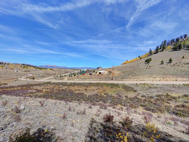 a view of a dry yard with wooden fence