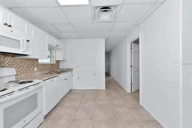 a kitchen with granite countertop a sink stove and cabinets